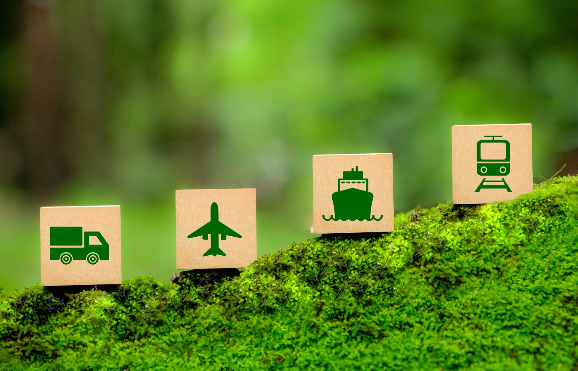 Green Logistics concept. Four wooden blocks, each with a green icon representing Green transportation- a truck, plane, ship, and train. eco-friendly transportation, sustainable logistics.